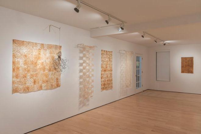 artwork using tea bags displayed on gallery walls