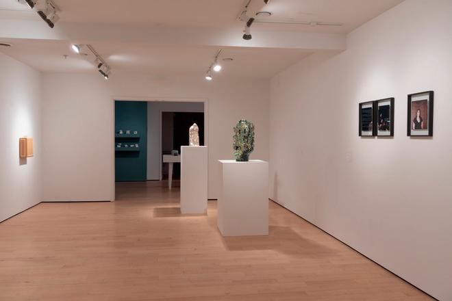 different corner of the gallery space with artwork on the wall and vases displayed